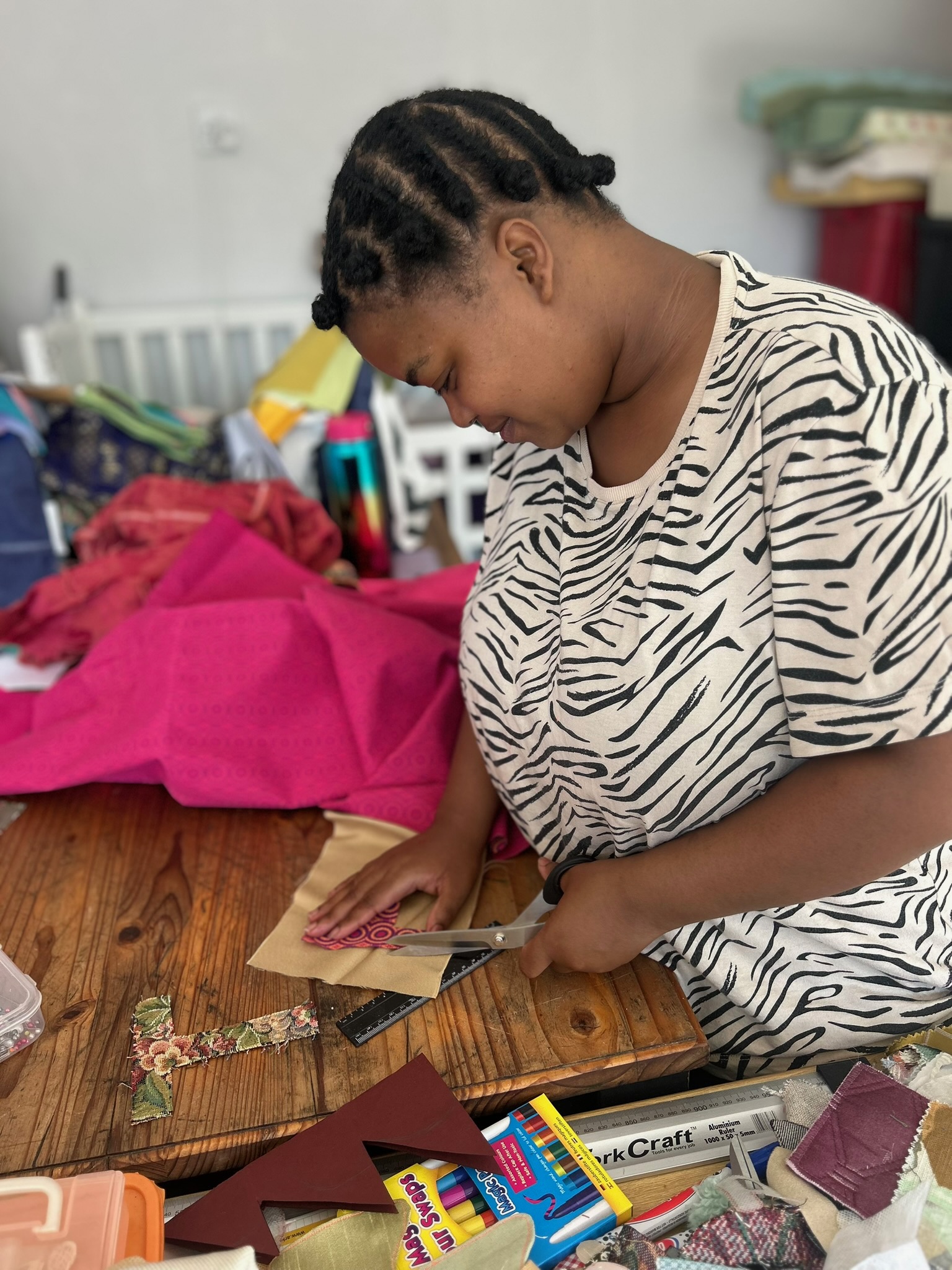A maker cutting fabric letters